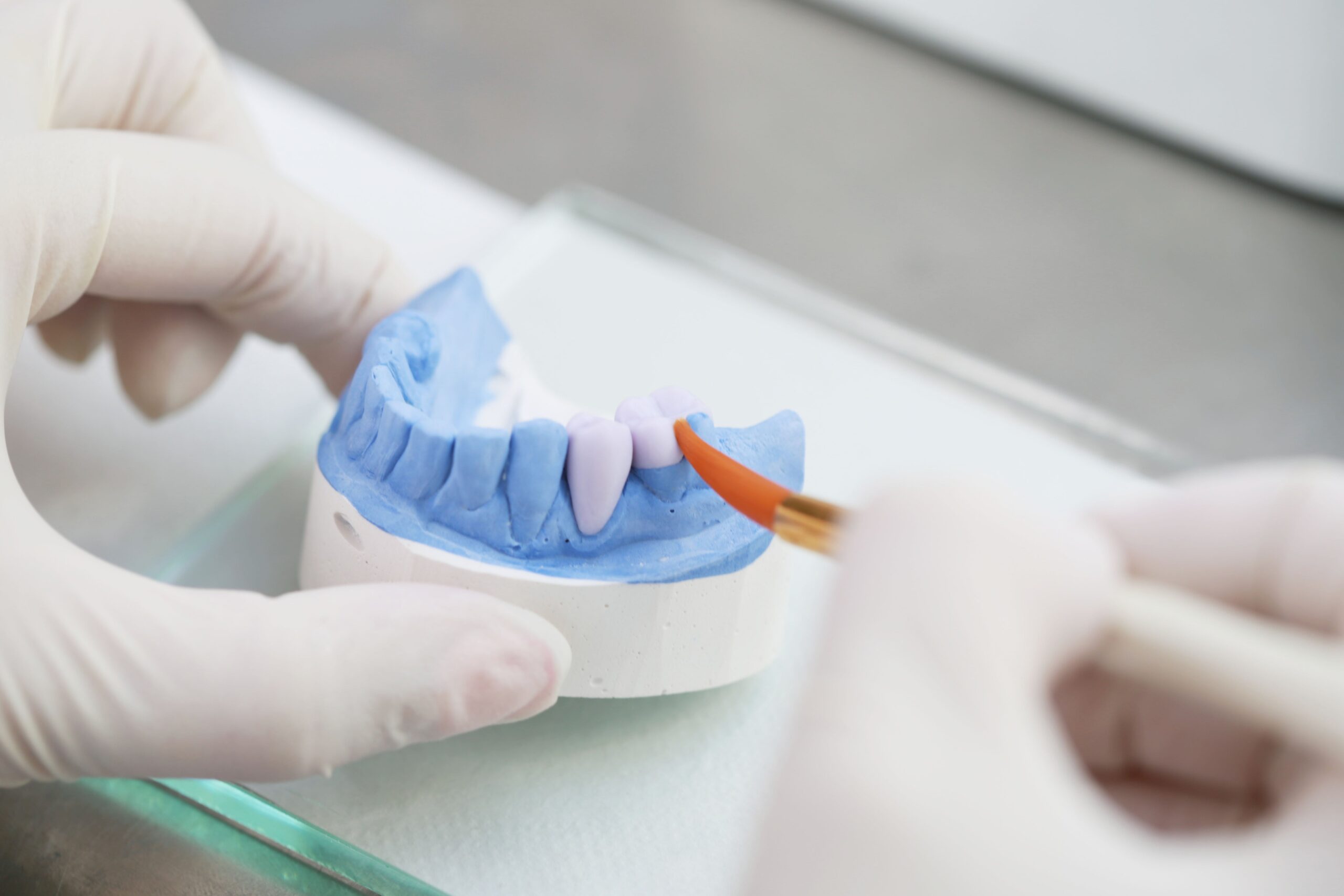 Master technician finishing a crown by hand in the in-house laboratory